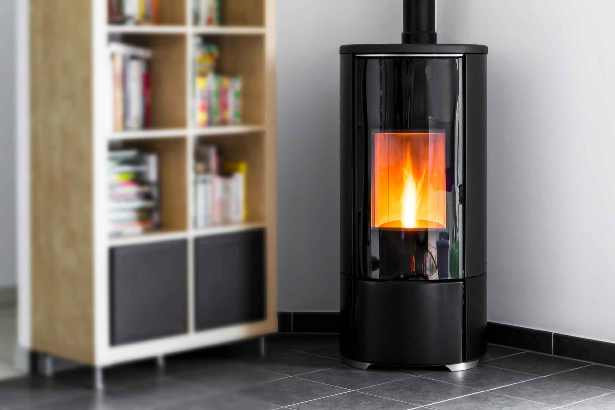Modern domestic pellet stove, granules stove with flames and lib